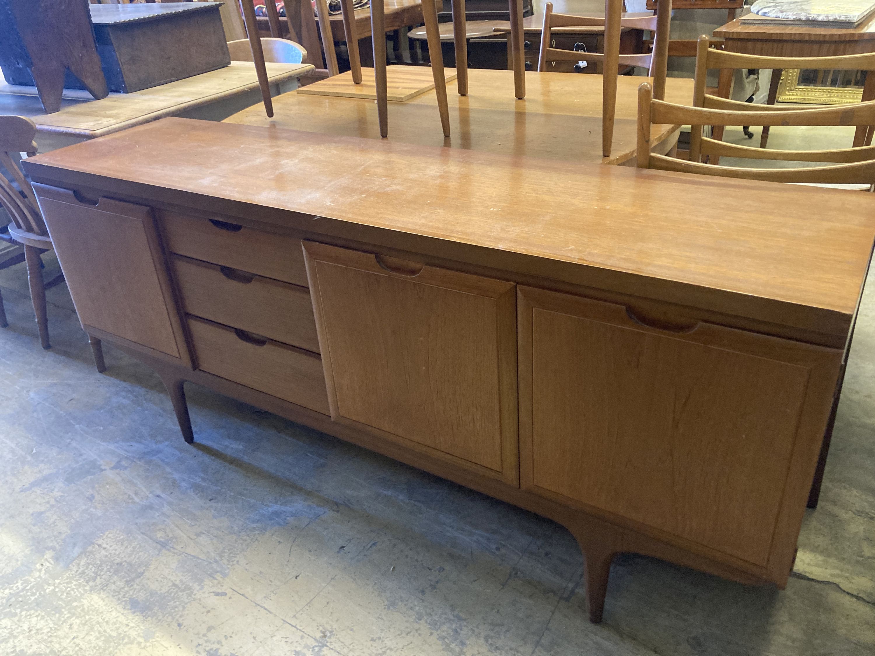 A mid 20th century Heals retailed teak dining suite comprising sideboard, extending dining table, length 127cm, width 90cm, height 74cm